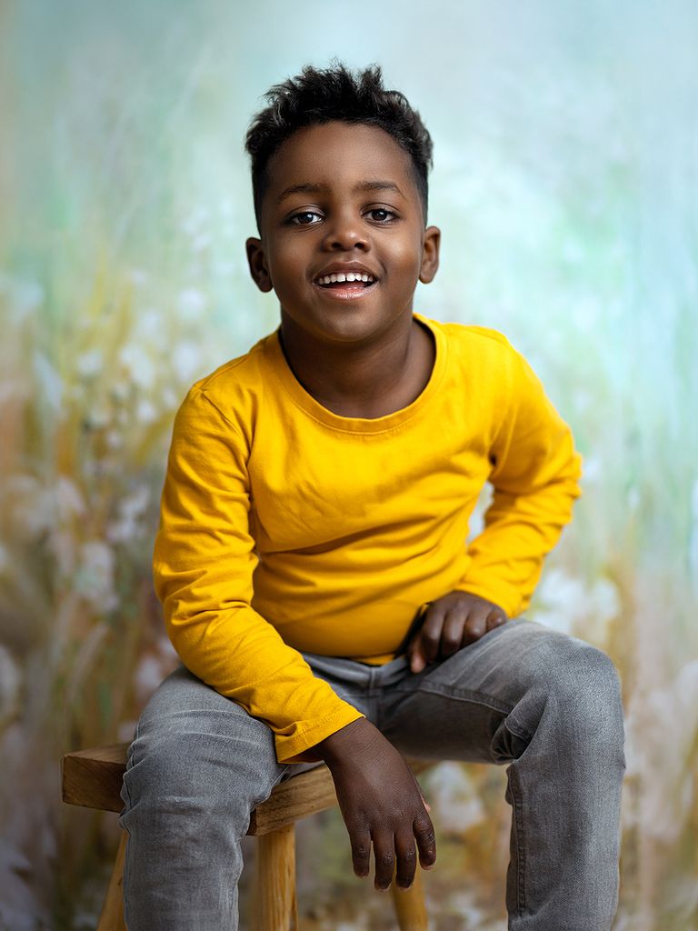 Kind lacht während des Kita Fotoshootings vor malerischem Hintergrund