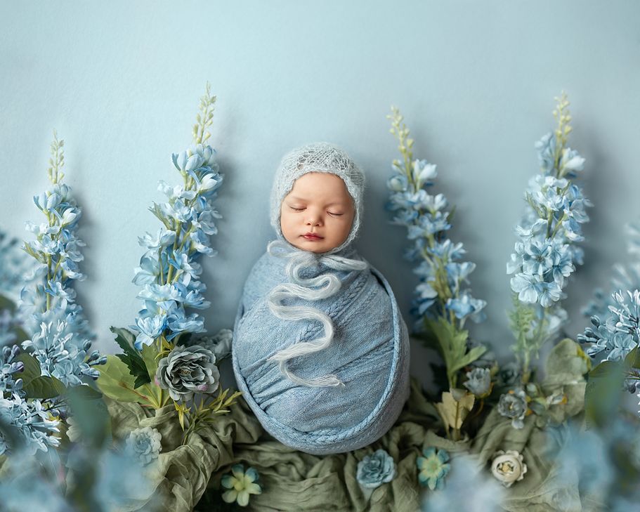 Künstlerische Neugeborenenfotografie in Dortmund – Baby in weichem Licht mit Blumen inszeniert