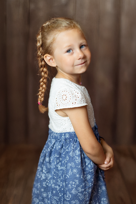Lächelndes Mädchen Kindergartenkind vor Holzwand Kita Fotograf Dortmund